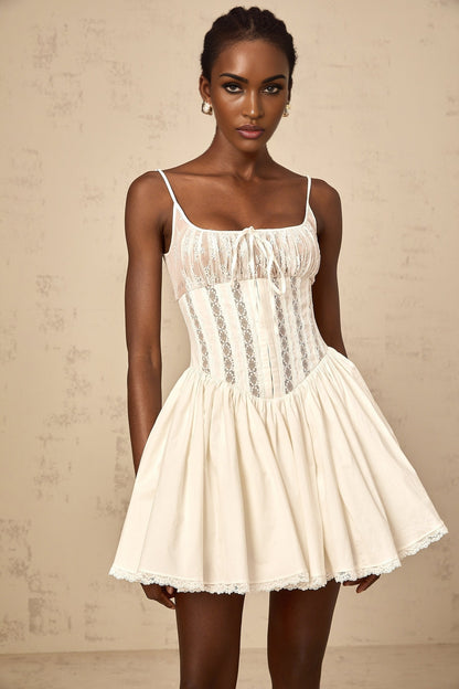 A white mini dress with lace details and a corsetstyle bodice featuring a fitted silhouette and delicate floral accents