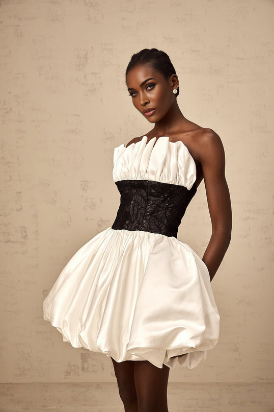 A white mini dress with puff sleeves and lace panels made from satin fabric