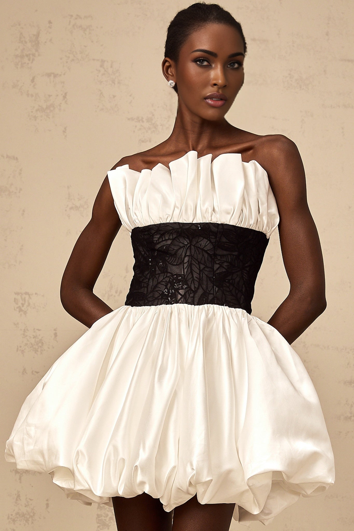A white mini dress with puff sleeves featuring lace paneling and a satin finish