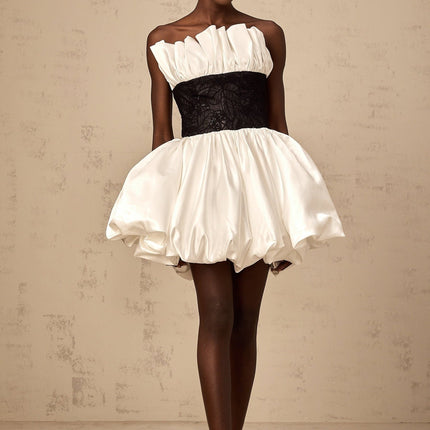 A white mini dress with puff sleeves featuring lace panelling and a satin finish