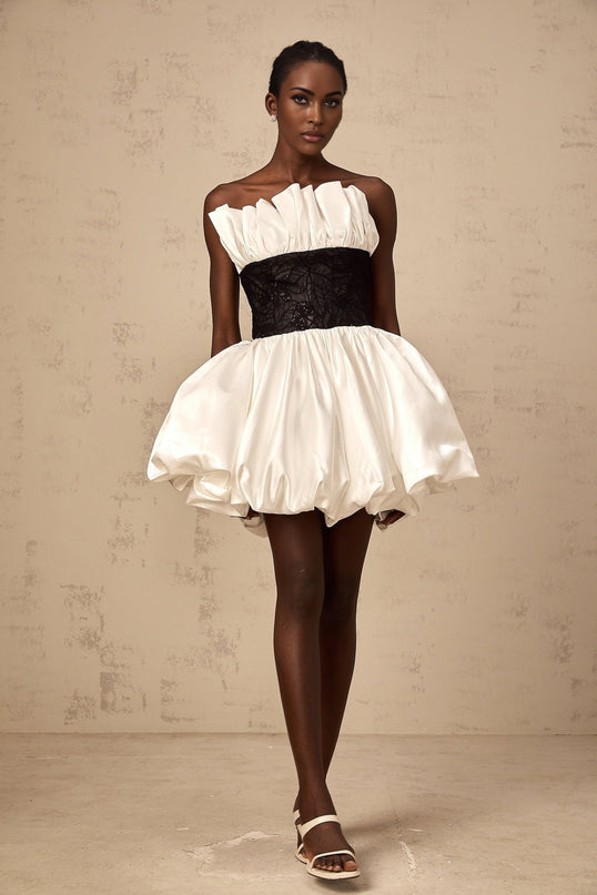 A white mini dress with puff sleeves featuring lace panelling and a satin finish