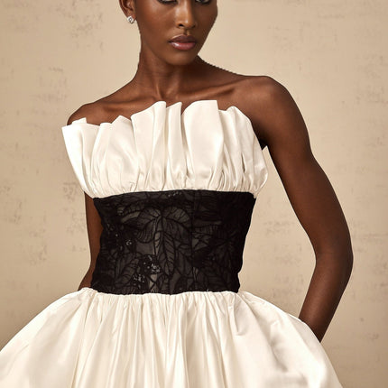 A white mini dress with puff sleeves featuring lace panelling and a satin finish