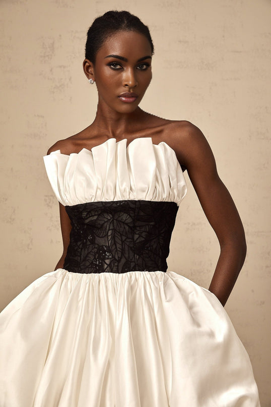 A white mini dress with puff sleeves featuring lace panelling and a satin finish