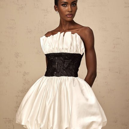 A white mini dress with puff sleeves featuring lace panelling and satin fabric