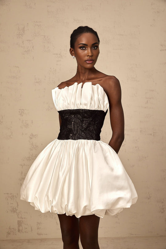 A white mini dress with puff sleeves featuring lace panelling and satin fabric