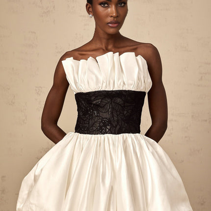 A white mini dress with puff sleeves featuring lace panels and a satin fabric