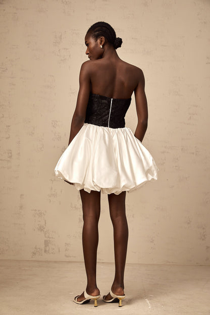 A white mini dress with puff sleeves featuring lace panels and a satin finish named Éliane