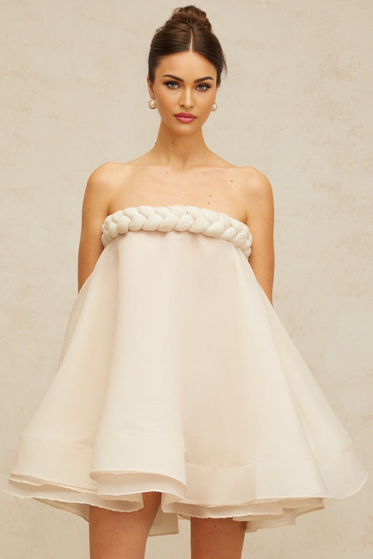 A white mini dress with puffed sleeves and braided detailing named Violette