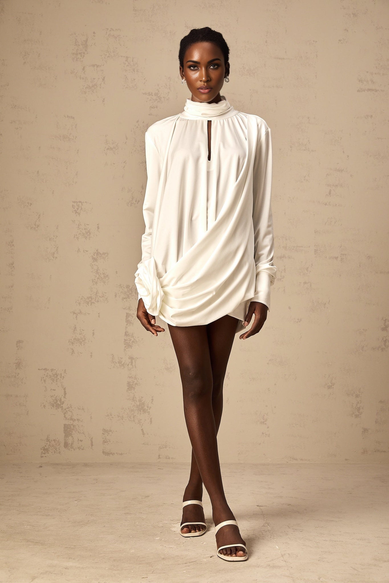 A white mini dress with ruched details and faux flower embellishments named Maeva