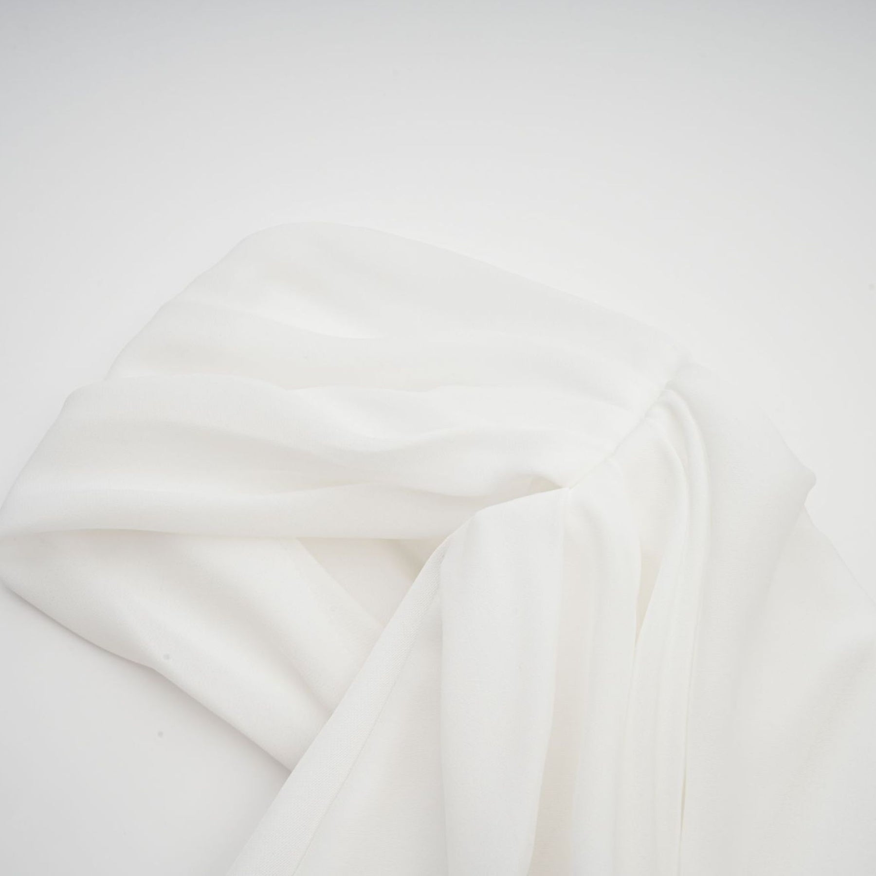 A white mini dress with ruched fabric and ribbon design details featuring a short hemline and fitted silhouette