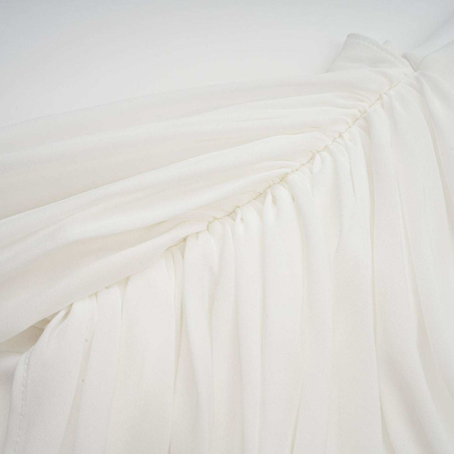 A white mini dress with ruched fabric and ribbon design details named Gitta