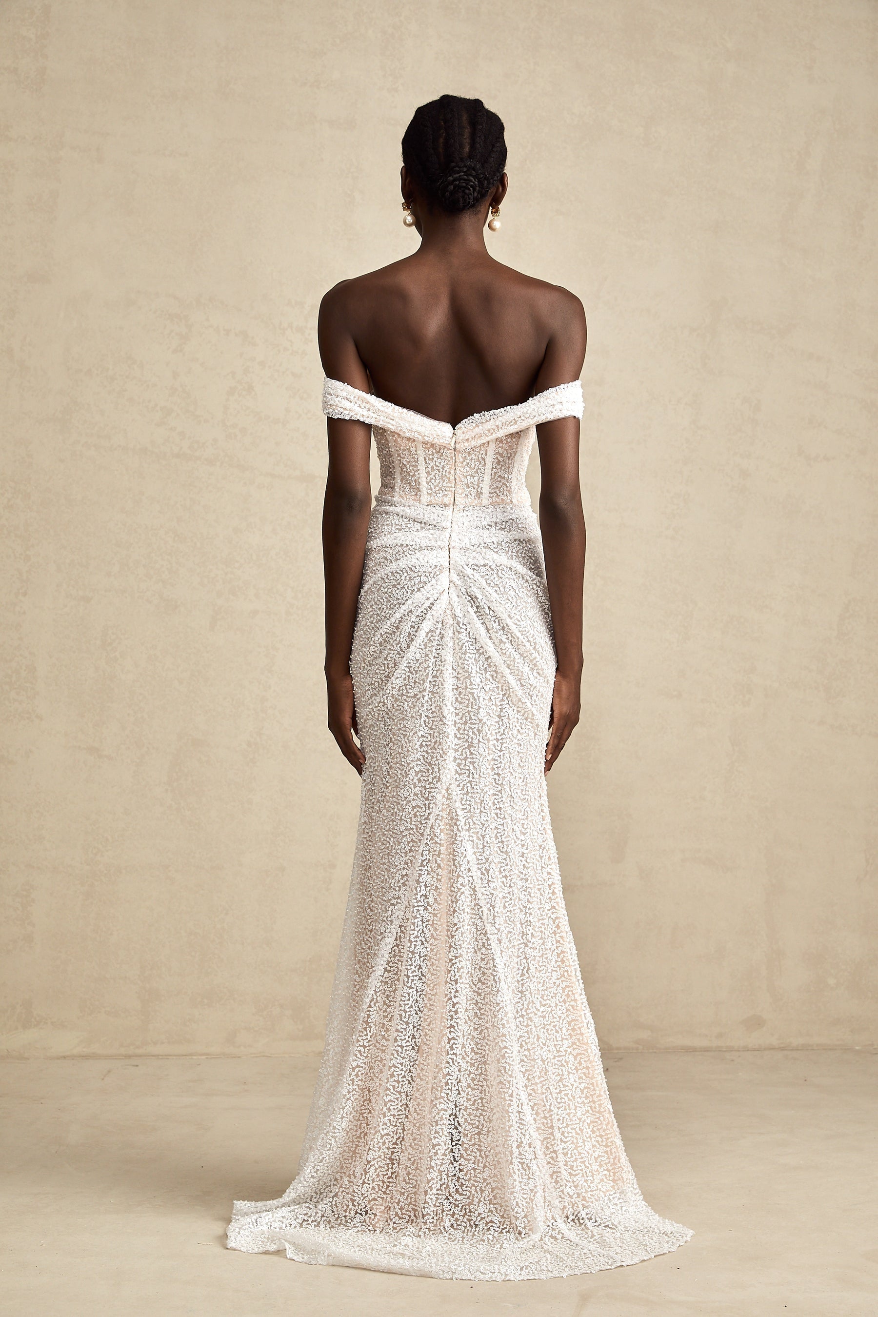 A white offshoulder maxi dress with embellishments named Margot featuring a long flowing skirt and decorative details on the bodice