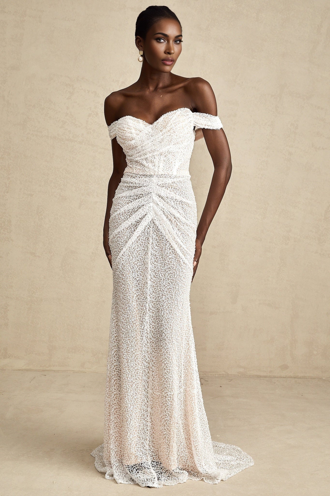 A white offshoulder maxi dress with embellishments named Margot worn by a model against a plain background