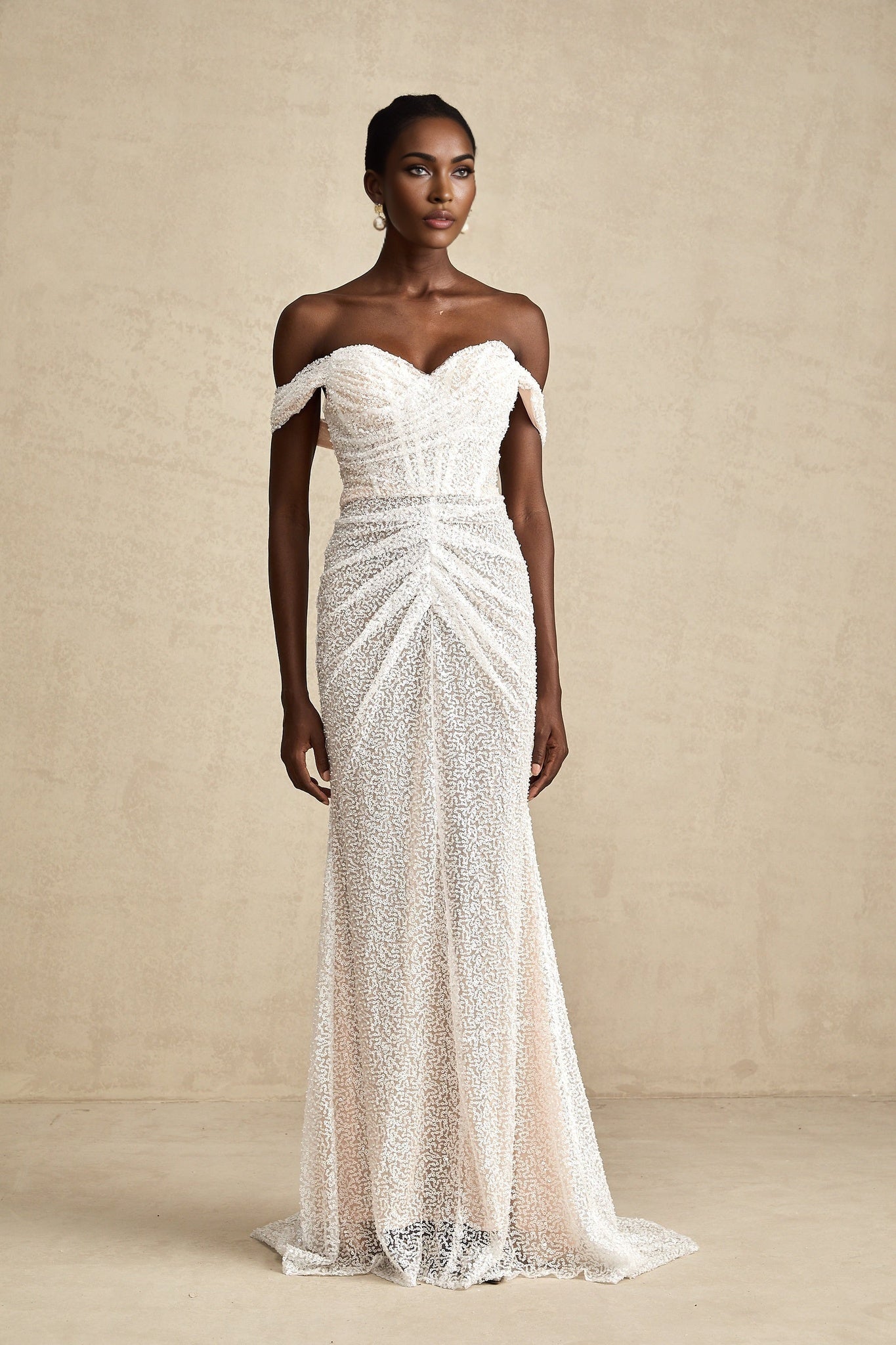 A white offshoulder maxi dress with embellishments worn by a model named Margot