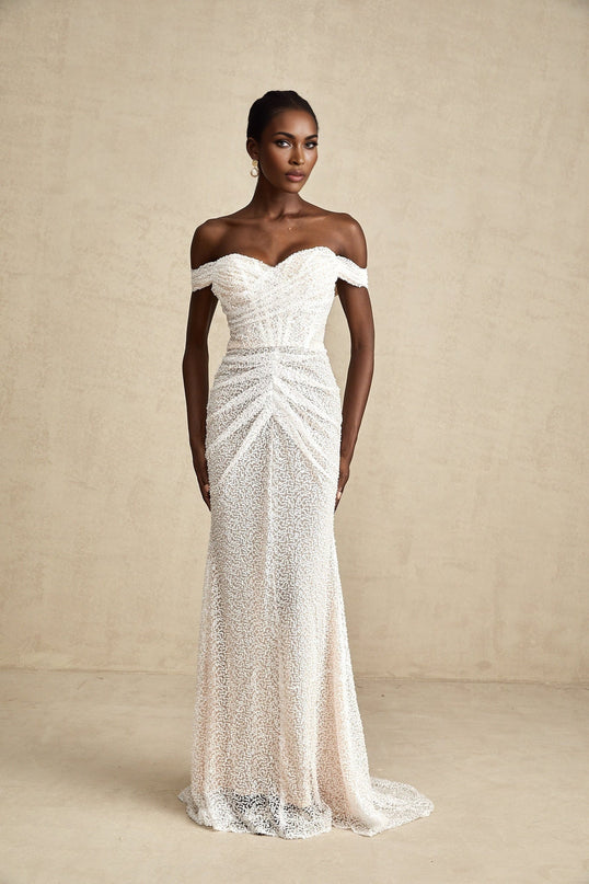 A white offshoulder maxi dress with embellishments worn by a model named Margot