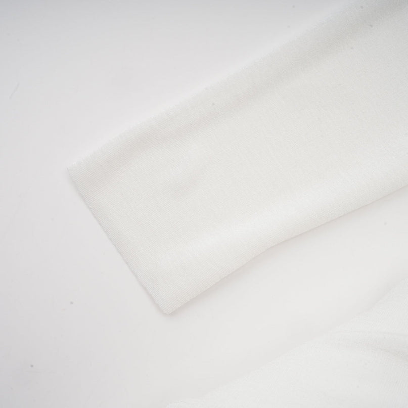 A white offshoulder maxi dress with panel detailing worn by a model named Nadine