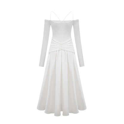 A white offshoulder maxi dress with panel details worn by a model standing against a plain background