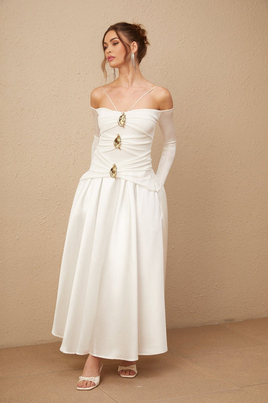 A white offshoulder maxi dress with panelled design worn by a model standing against a plain background