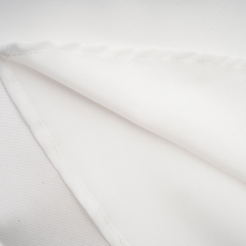 A white offshoulder maxi dress with panelled design worn by a model standing against a plain background