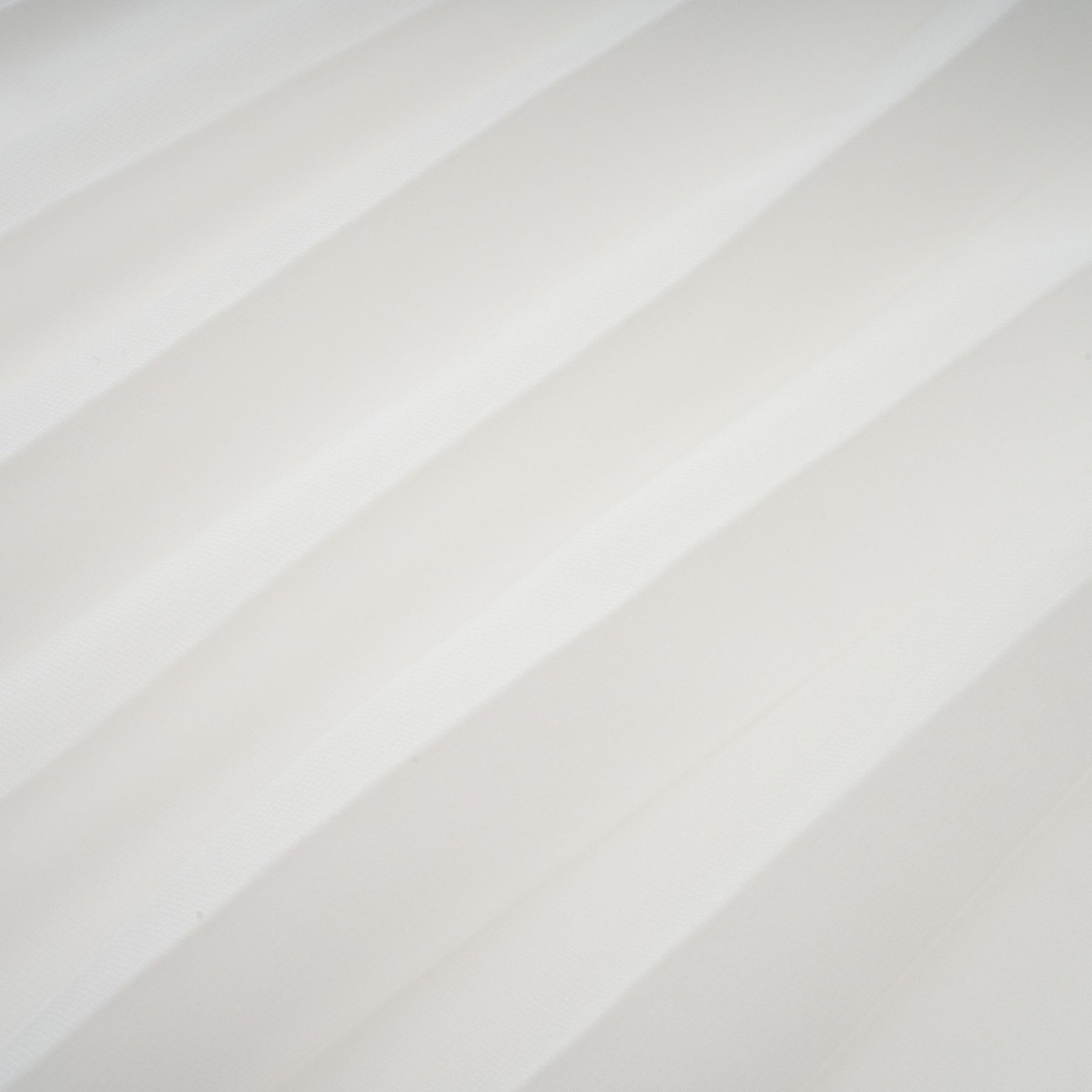 A white offshoulder maxi dress with pleated details and a flowing silhouette worn by a model named Vanessa