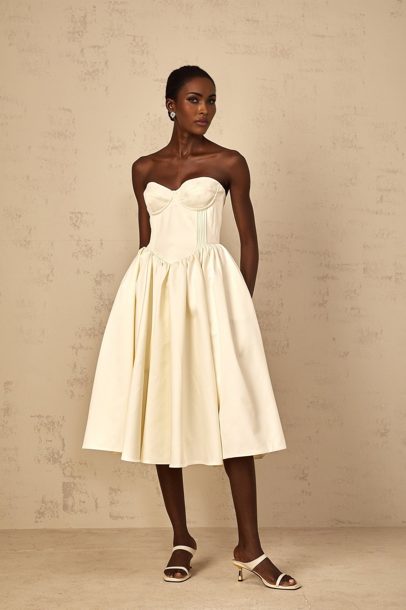 A white offshoulder midi dress with shirred detailing worn by a woman named Noor