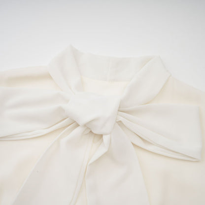 A white pleated jacket and dress set with embellishments featuring a matching design The jacket is worn over the dress creating an elegant coordinated outfit