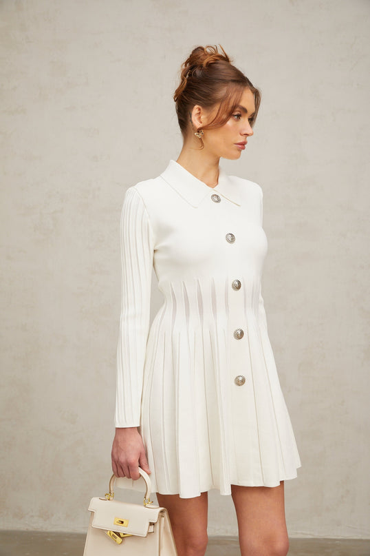 A white pleated knit mini dress named Emeline on a plain background