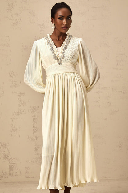 A white pleated midi dress with crystal trim detailing along the neckline and waist named Yana