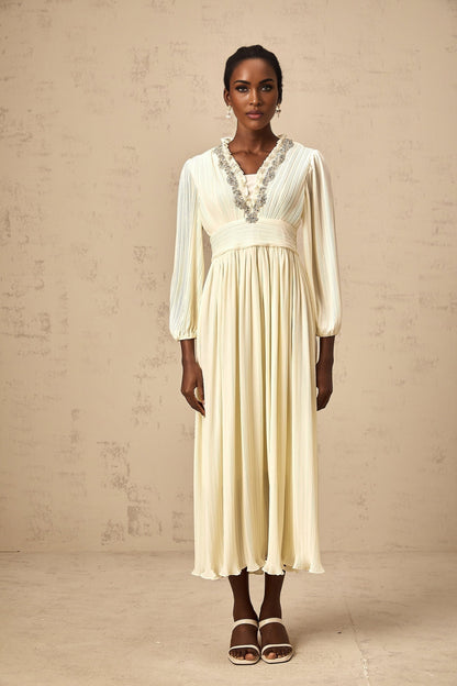 A white pleated midi dress with crystal trim detailing named Yana