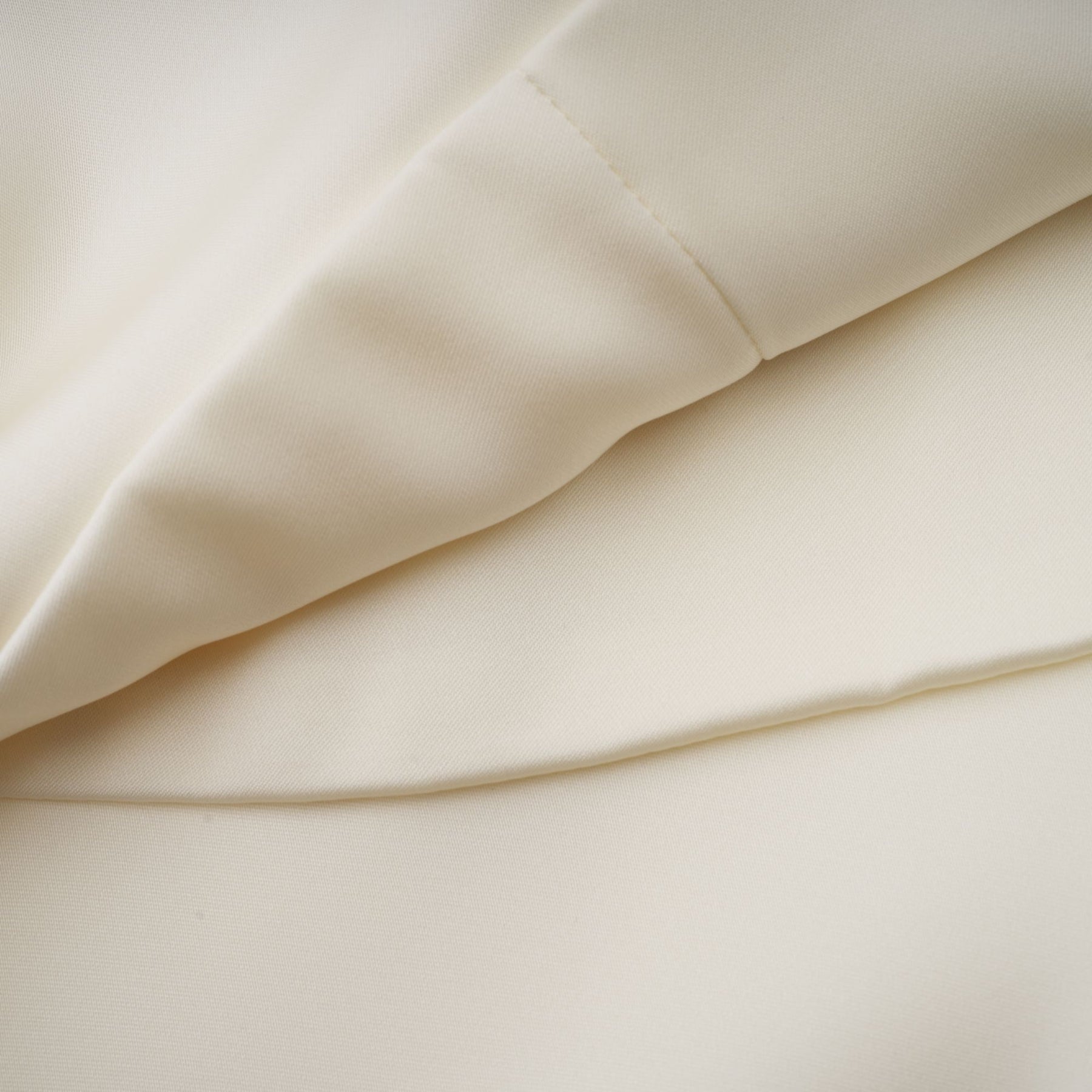 A white satin mini dress with ruffled details and a shawl panel accent shown on a model against a plain background