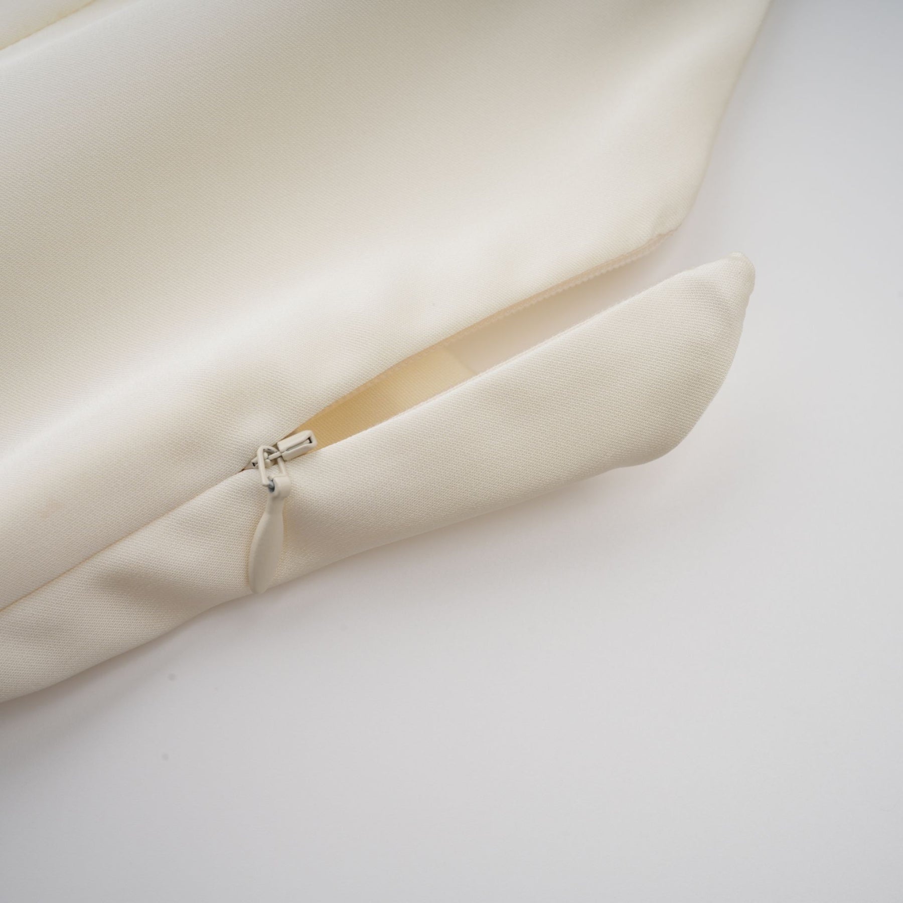 A white satin mini dress with ruffled details and a shawl panel featuring a short hemline and elegant design