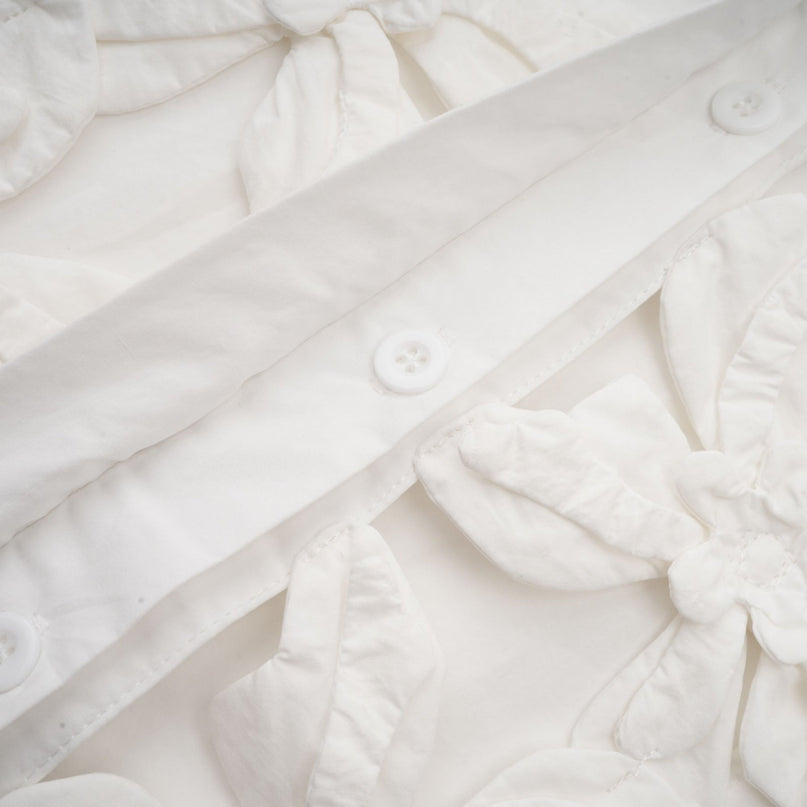 A white shirt with a floral pattern featuring cut out details named Rosalie