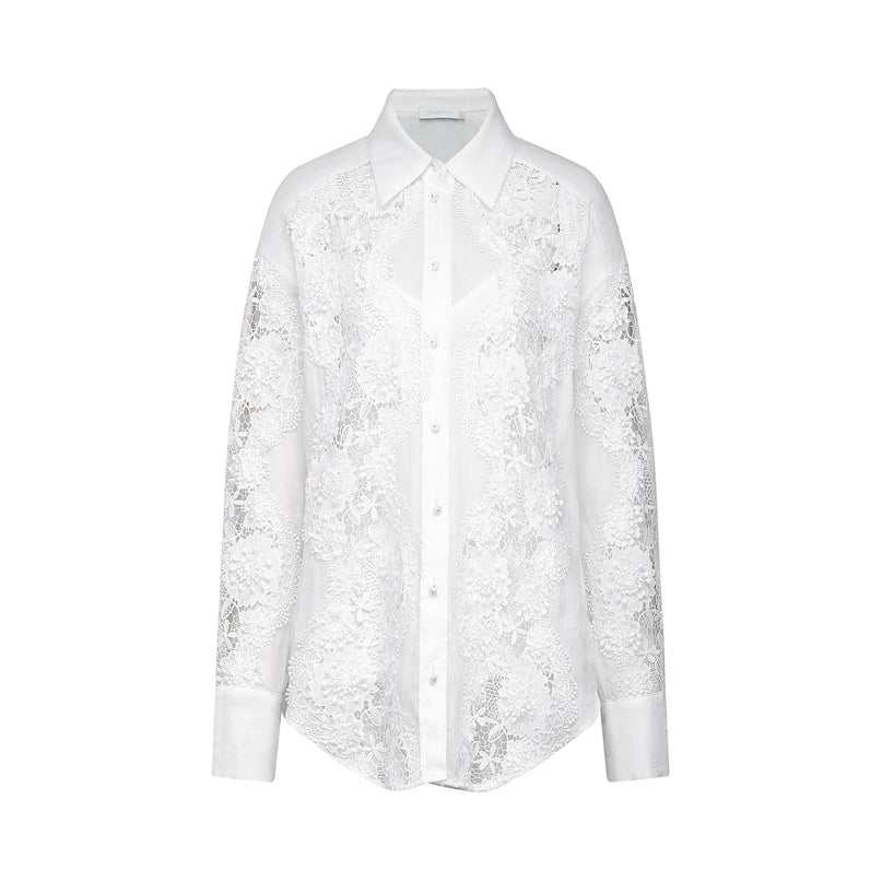 A white shirt with delicate lace embroidery and strategic cut out details featuring long sleeves and a collar