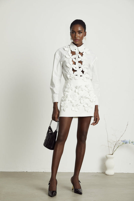 A white shirt with floral cutout patterns and a relaxed fit featuring the Rosalie design