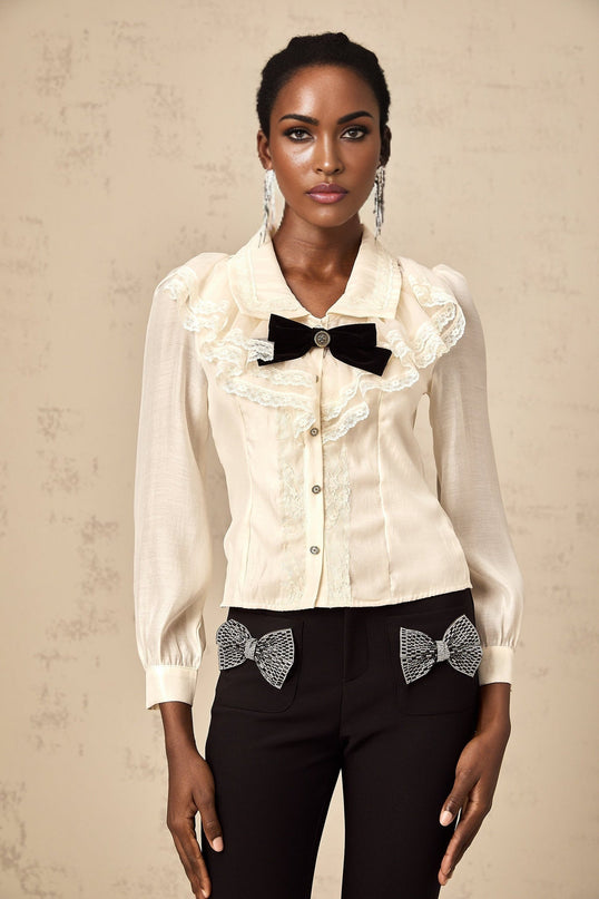 A white shirt with lace trim and a bow detail at the neckline named Alessia