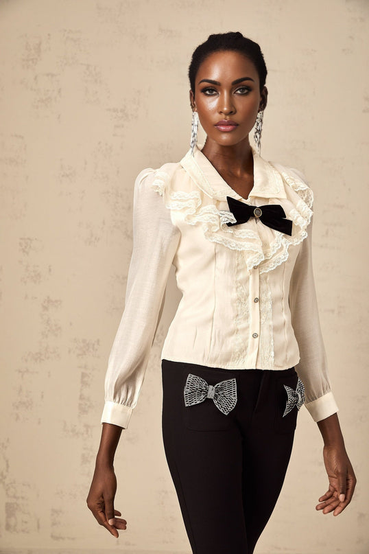A white shirt with lace trim and a bow detail at the neckline