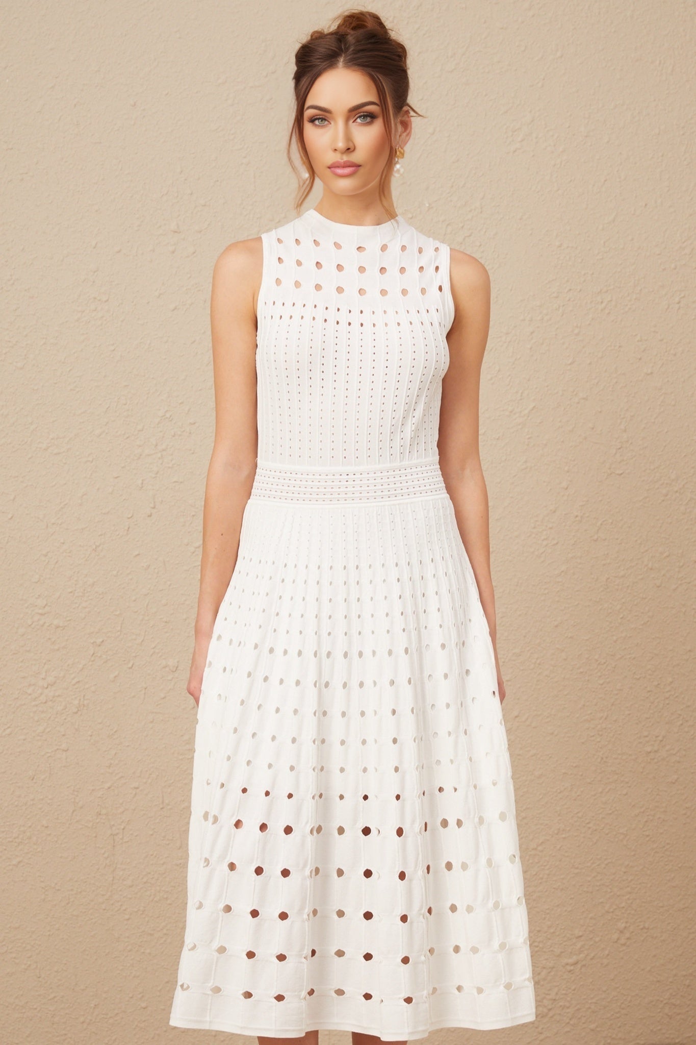 A white sleeveless knitted midi dress with cutout details modeled on a female figure against a plain background