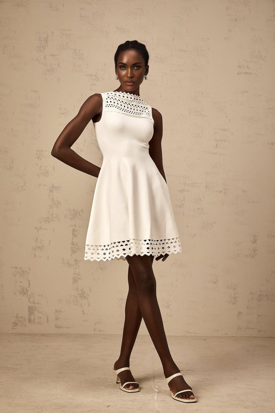 A white sleeveless knitted mini dress with cutout details featuring a slim fit and short length