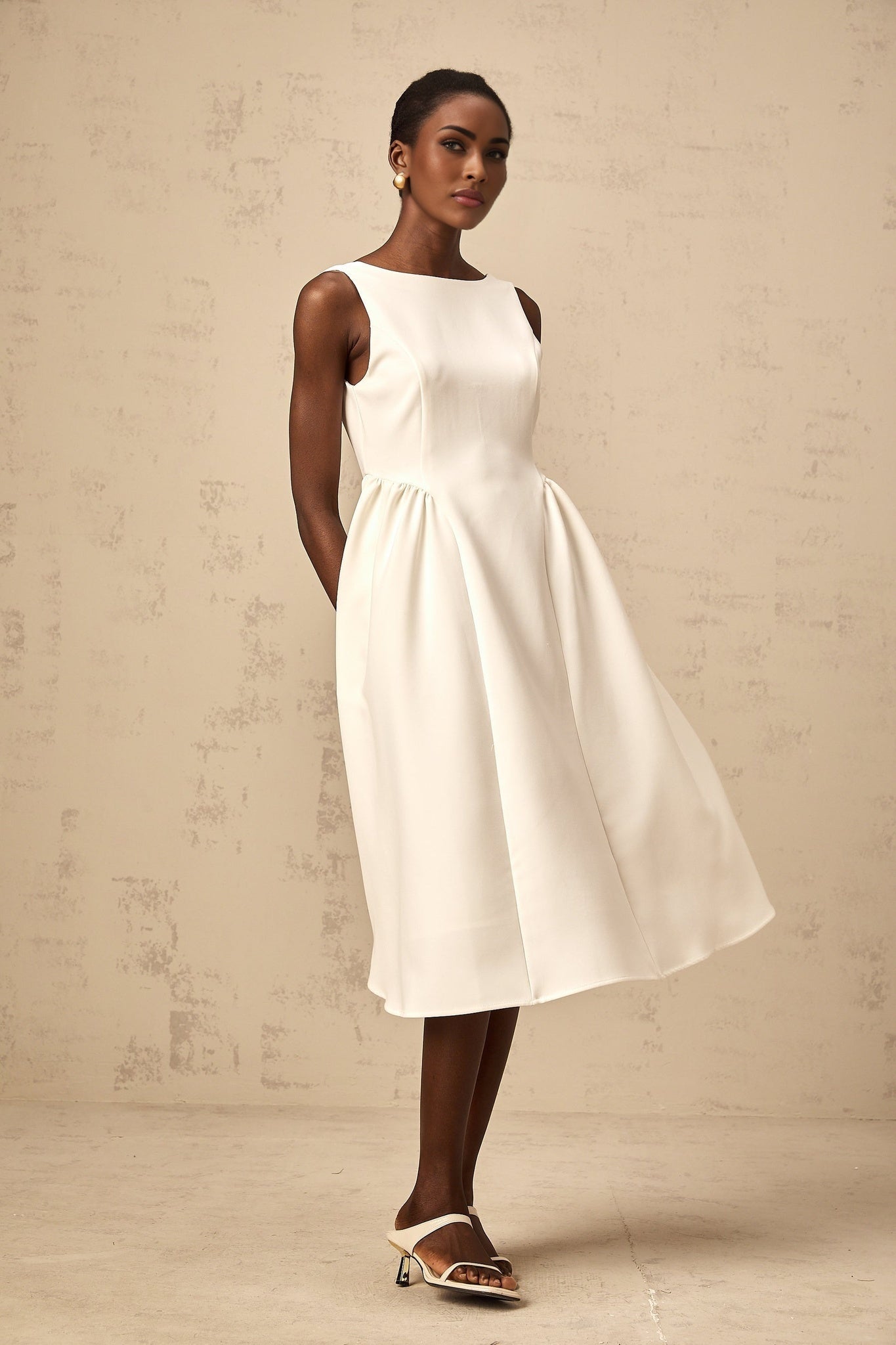 A white sleeveless midi dress with a full skirt named Yolanda