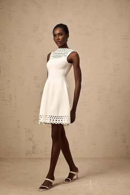 A white sleeveless mini dress with knitted fabric and cutout details featuring a short length and fitted silhouette