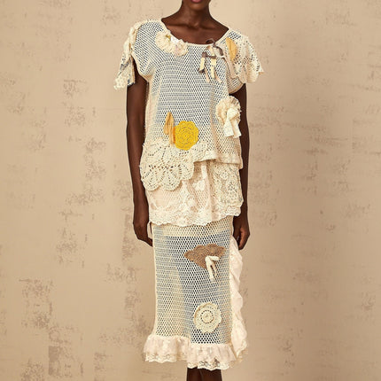 A white sleeveless top with a delicate lace panel and crochet knit detailing