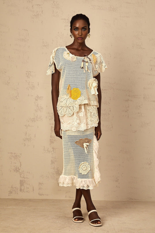 A white sleeveless top with a delicate lace panel and crochet knit detailing