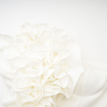 A white sleeveless top with delicate floral applique details adorning the fabric