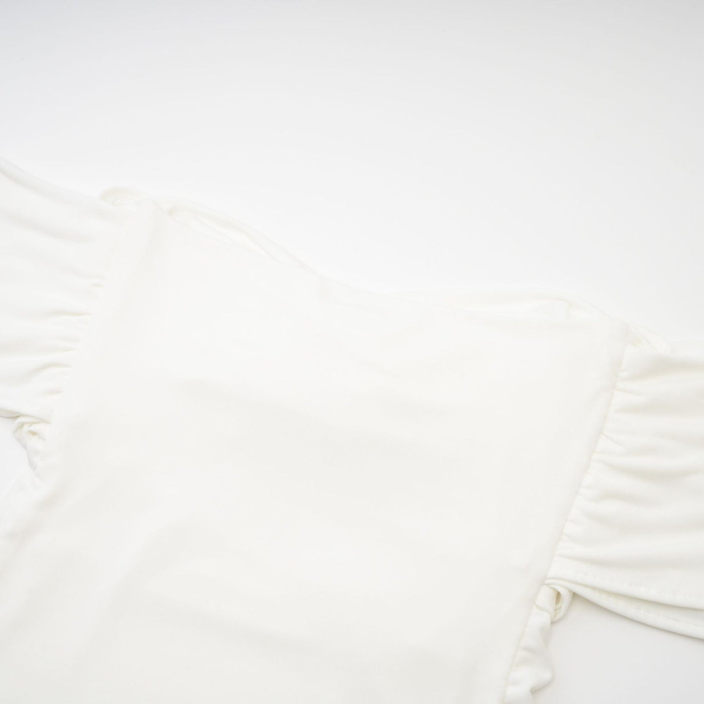 A white sleeveless top with gathered details featuring a feminine design and relaxed fit