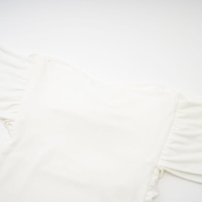 A white sleeveless top with gathered details featuring a feminine design and relaxed fit