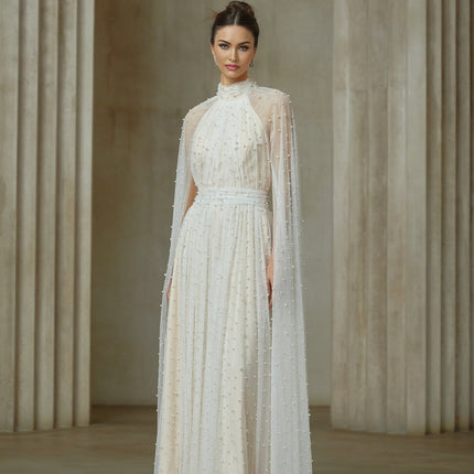 A white tulle maxi dress with cape design and embellishments featuring a flowy silhouette and delicate details