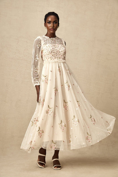 A white tulle midi dress with delicate floral embroidery featuring a sleeveless design and a flowy silhouette from the Celine collection