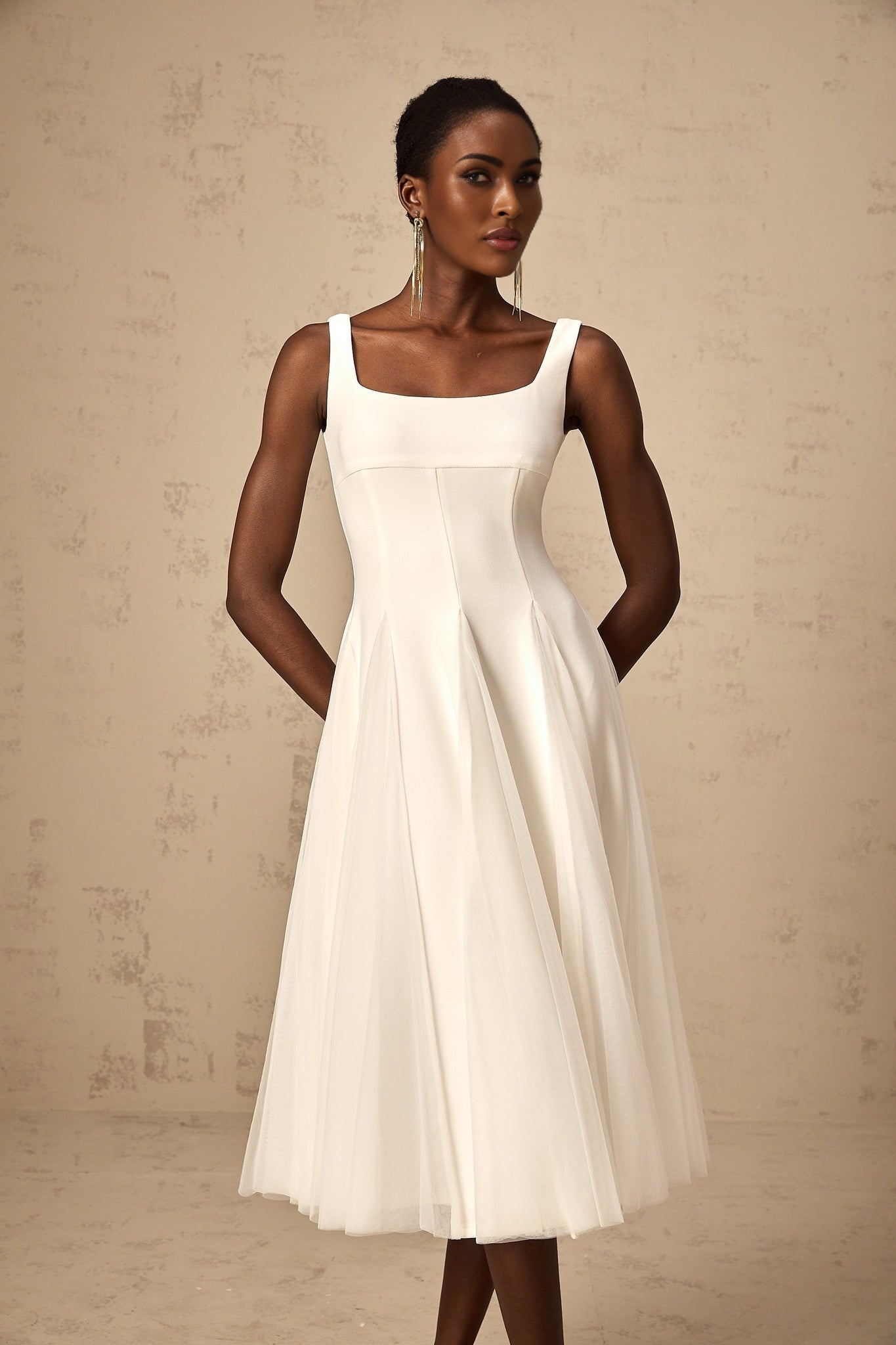 A white tulle midi dress with godet inserts featuring a fitted bodice and flared skirt named Danielle