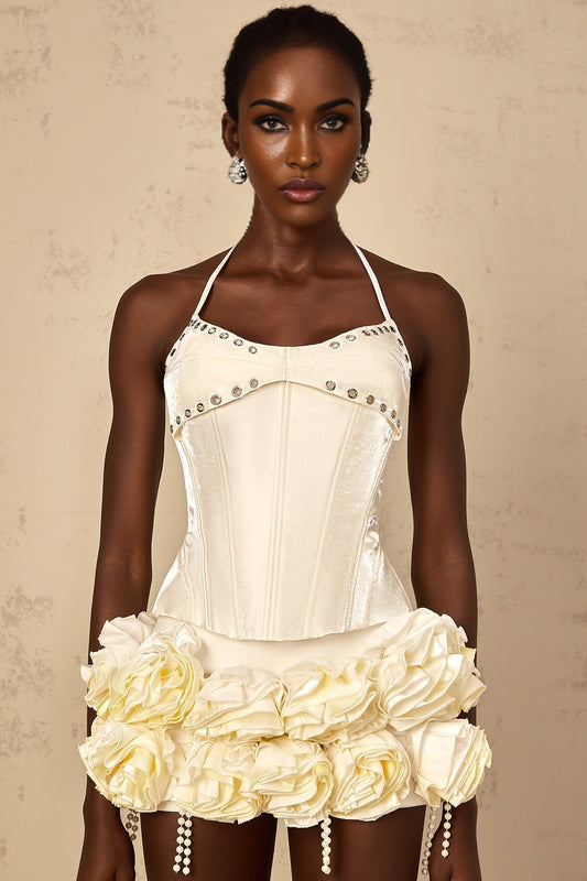 A white twopiece outfit consisting of a floral corset top and matching skirt with a Madeleine design pattern