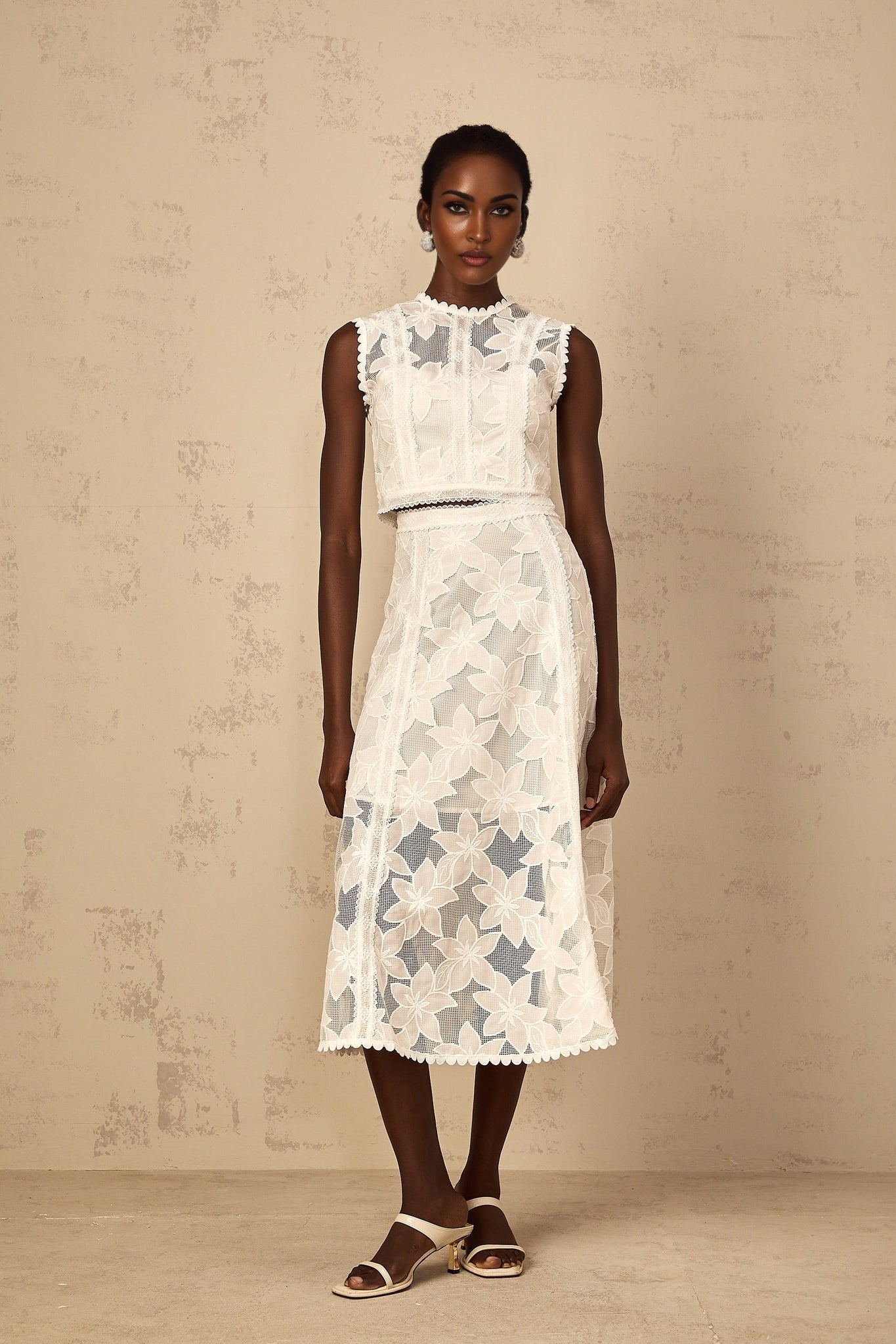 A white twopiece outfit consisting of a top and skirt with floral embroidery details named Mailys